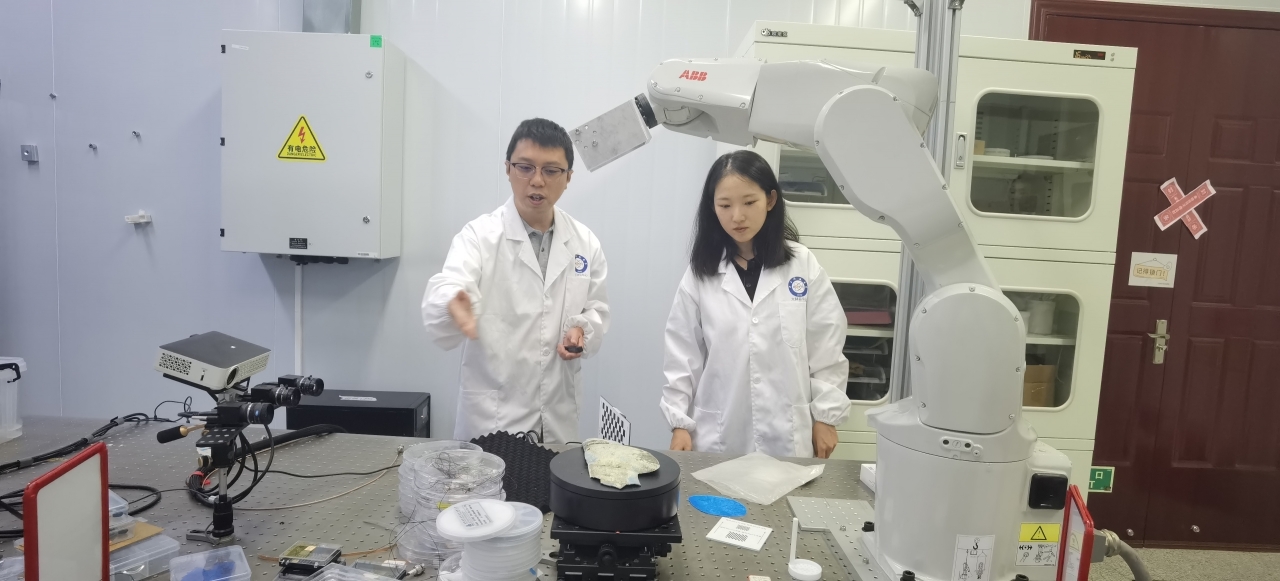 胡旻和张晓秋艳向记者介绍机械臂。罗莎摄